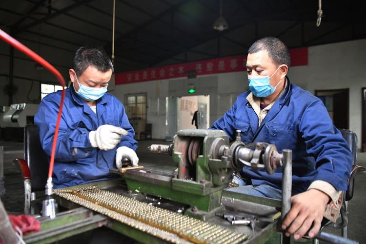 3月21日,工作人员在安康市石泉县城关镇一家电子元件厂加工产品.